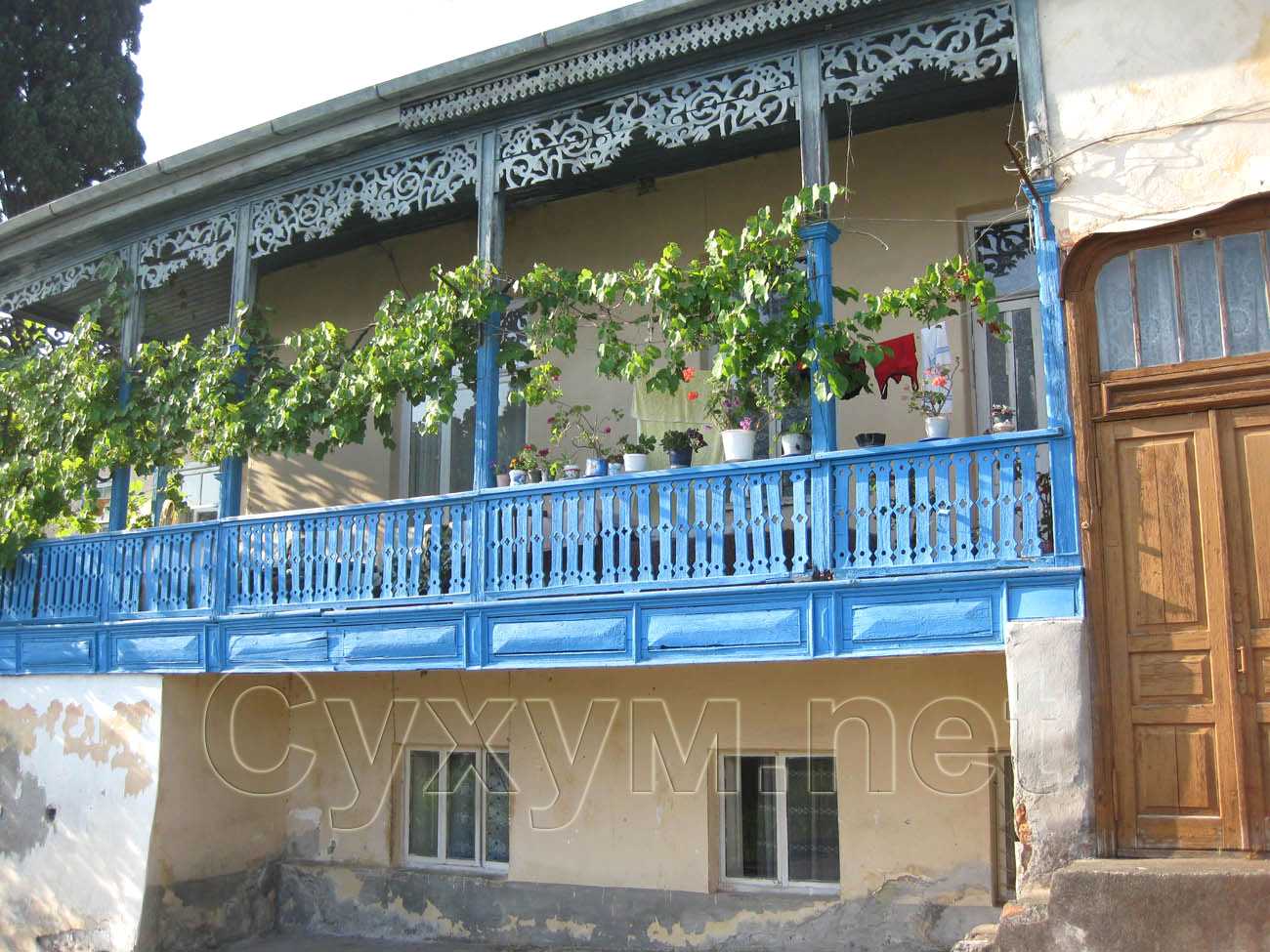 дом с синей деревянной верандой