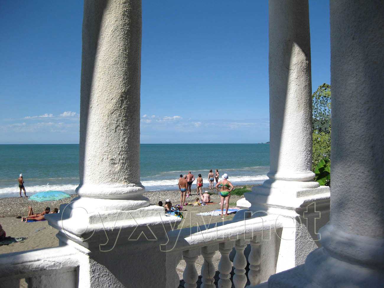 пляжники за колоннами арки